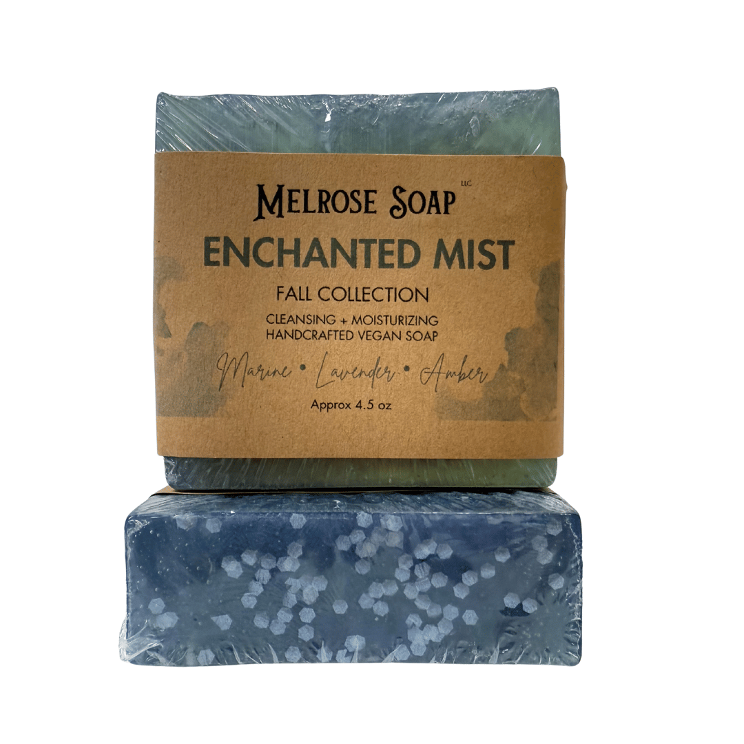 Enchanted Mist handcrafted vegan soap bars from Melrose Soap Fall Collection, labeled bar with marine, lavender, amber scent and second bar showing blue swirl design with white bio-glitter, approx. 4.5 oz.