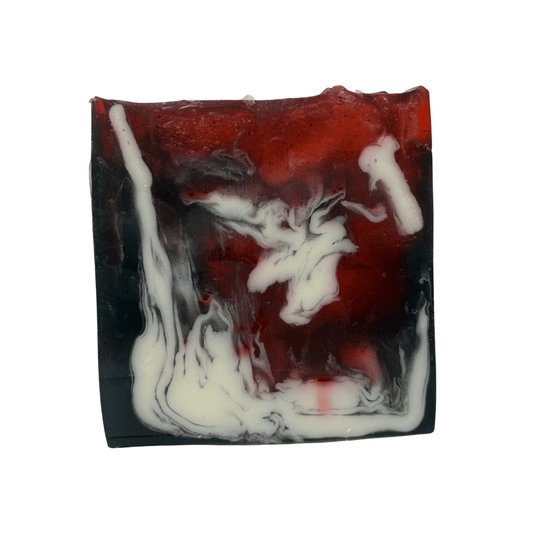 Front view of Moonlit Cherry Goat Milk & Activated Charcoal Soap. A moisturizing handcrafted fall soap with striking red, black, and white swirls.