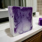 Handcrafted Sea Salt and Orchid Goat Milk soap bar on counter with notes of sea salt and freesia, with purple and white swirls.