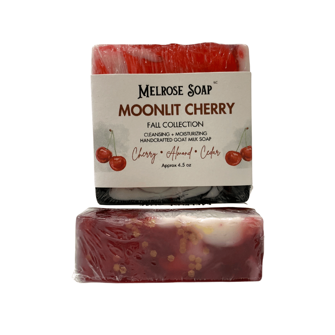 Moonlit Cherry handcrafted goat milk soap from Melrose Soap Fall Collection, labeled bar with cherry, almond, cedar scent and second bar showing red swirl design.
